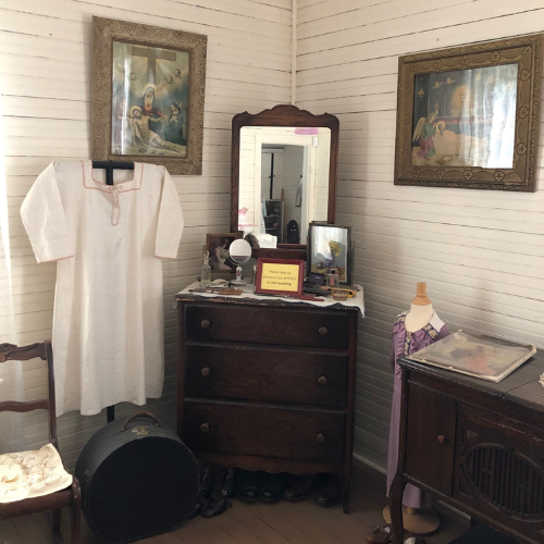 Room interior showing dresser, nightgown, and mirror