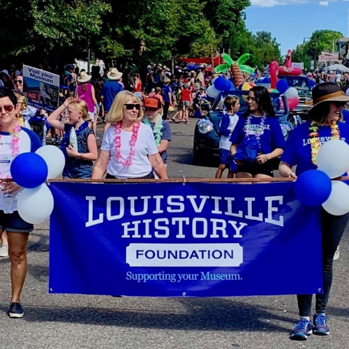 People marching in a parade holding a banner