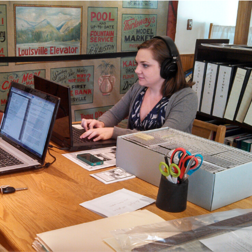 Woman wearing headphones working on laptop