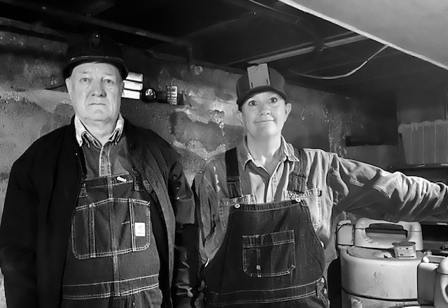 Man and woman in overalls dressed as miners from the Acme Mine.