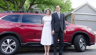 Man and woman standing in front of a car.