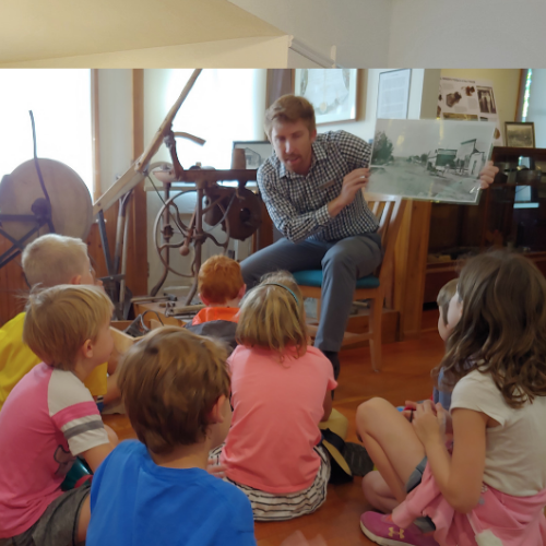 Man showing photograph to school children