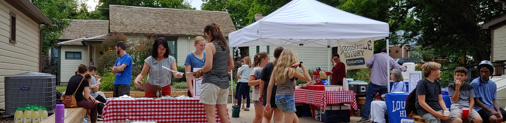 Crowds of people at outdoor event with tables and activities