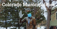 Photo of Colorado Municipalities Magazine Cover featuring statue of John Breaux that has had a mask put on it.