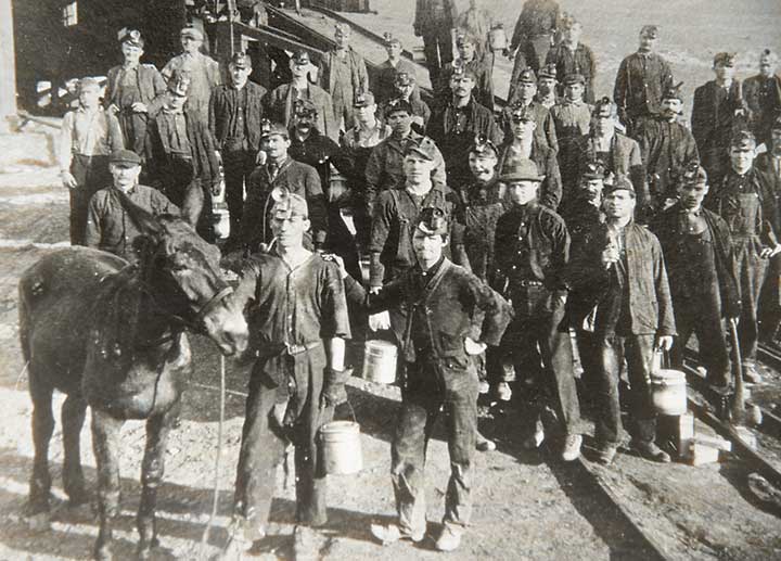 Large group of miners and a mule outside the Vulcan Mine