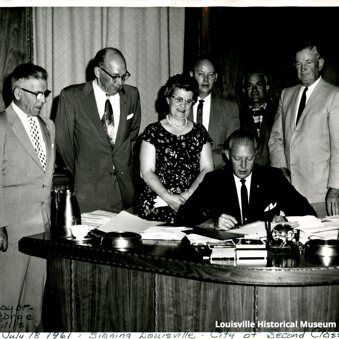 Susie DiGiacomo attends as Governor McNichols signs the document to make Louisville a 