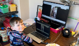 boy watches preschool tour on a computer