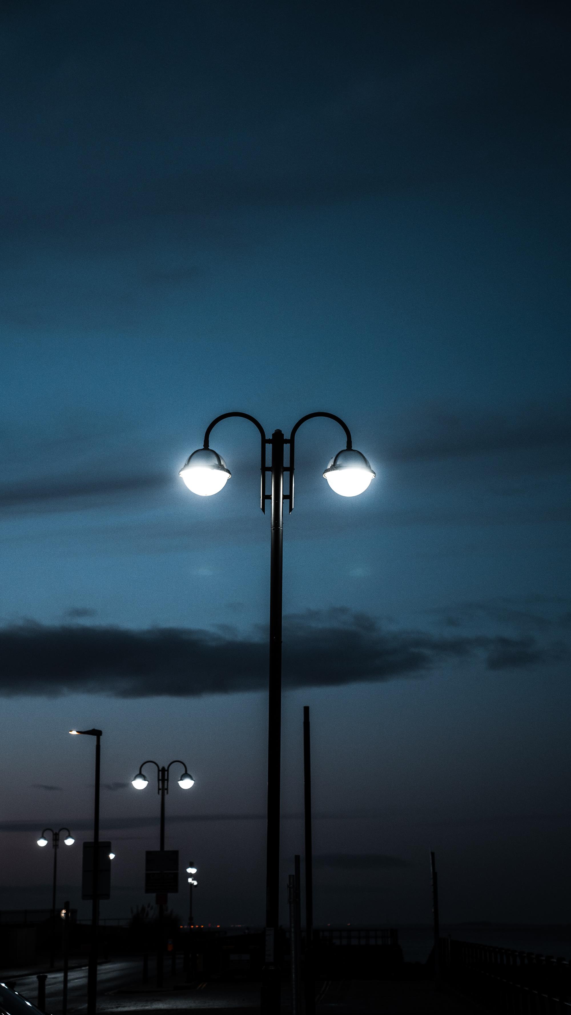 Multiple lamp posts at night with lights on