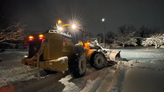 snowplow clearing snow at night