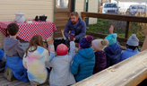 Museum staff talked to seated students outside