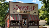 Photo of the Louisville Historical Museum, a wood structure with awnings and large front windows