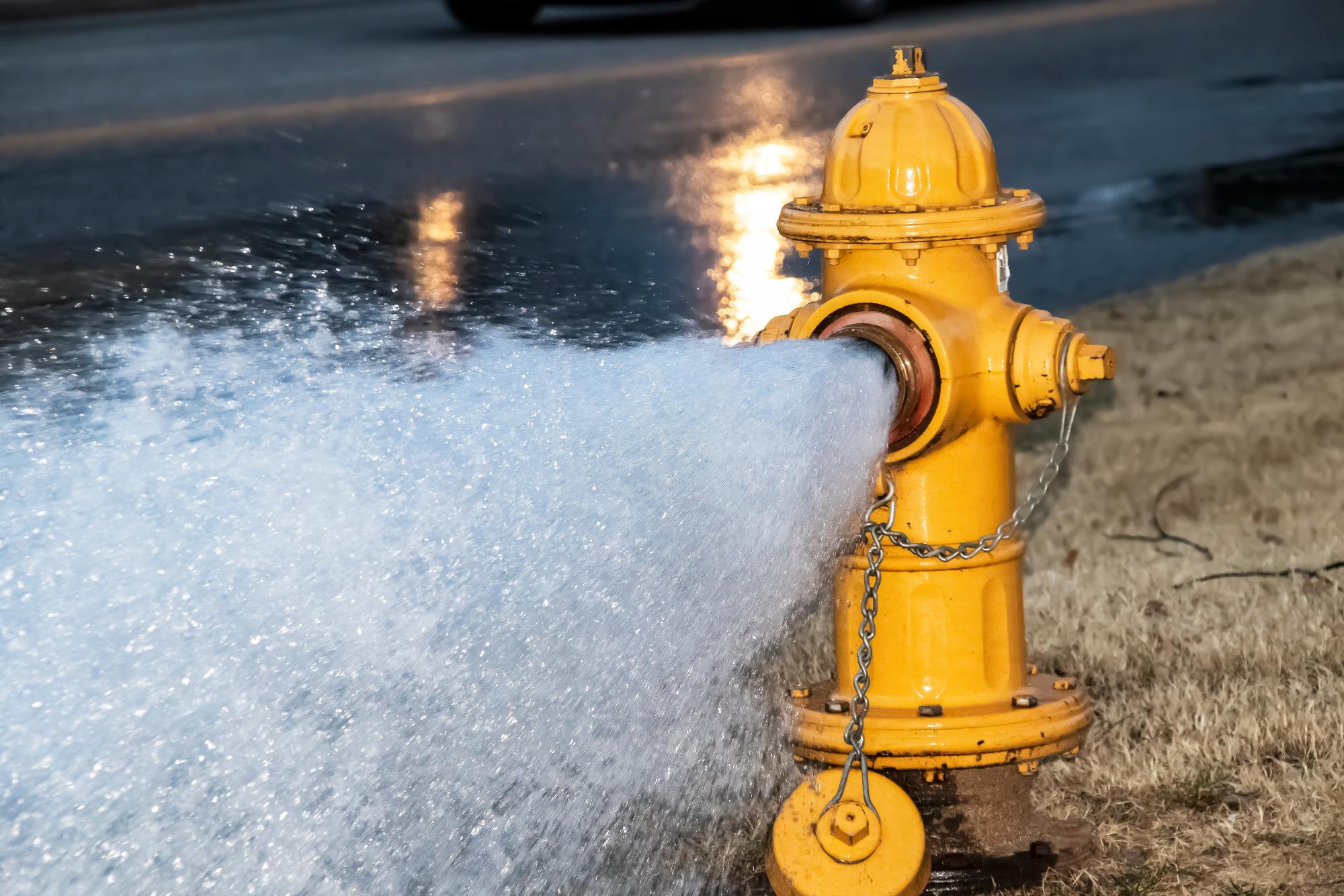 Open fire hydrant with water blasting out