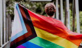 Photo of a youth with an LGBTQ Pride flag