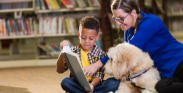 Child reading to therapy dog