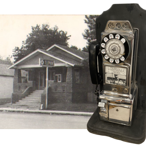 black and white photo of brick building with "telephone" sign and a vintage payphone