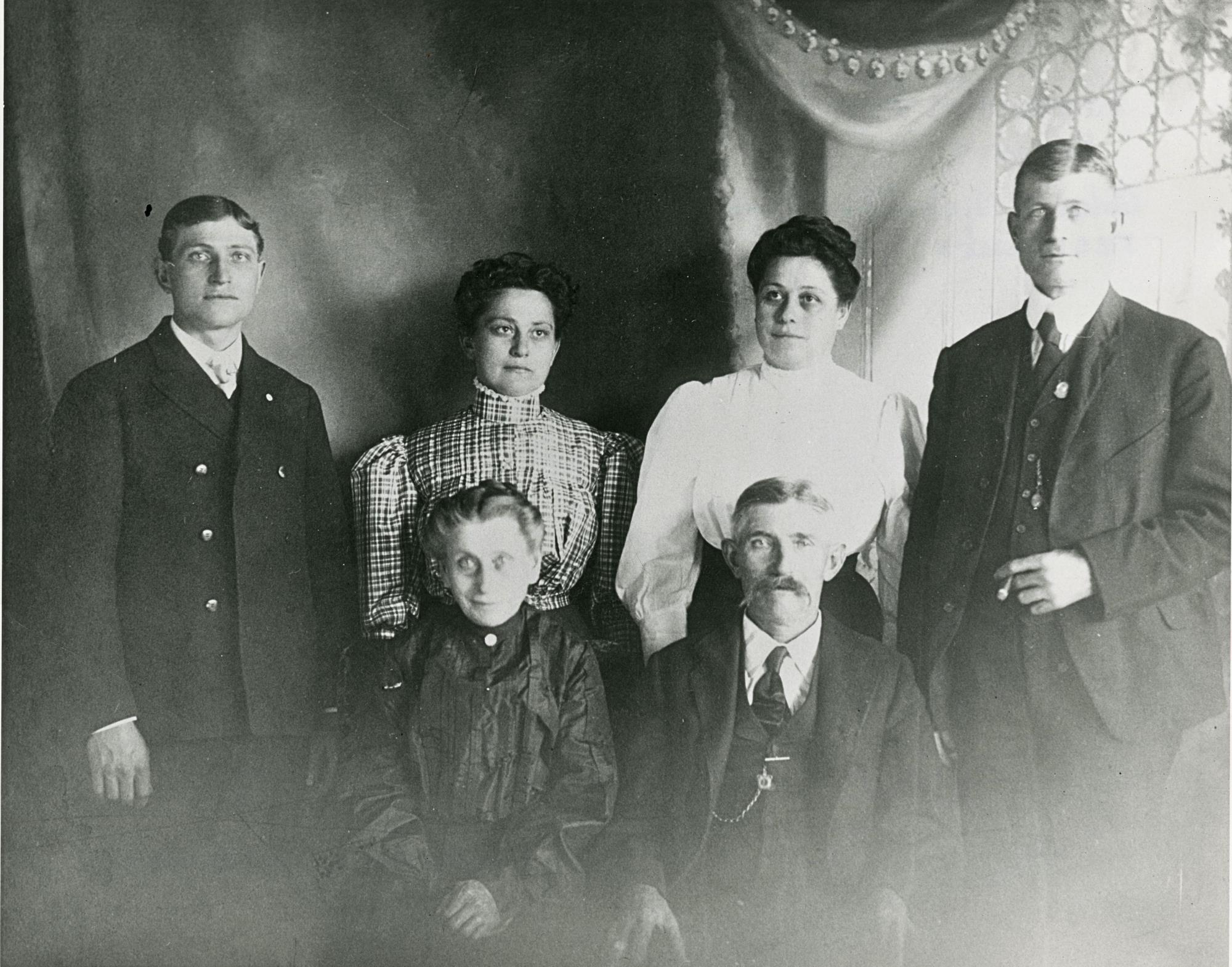 Formal portrait of elderly parents and four adult children