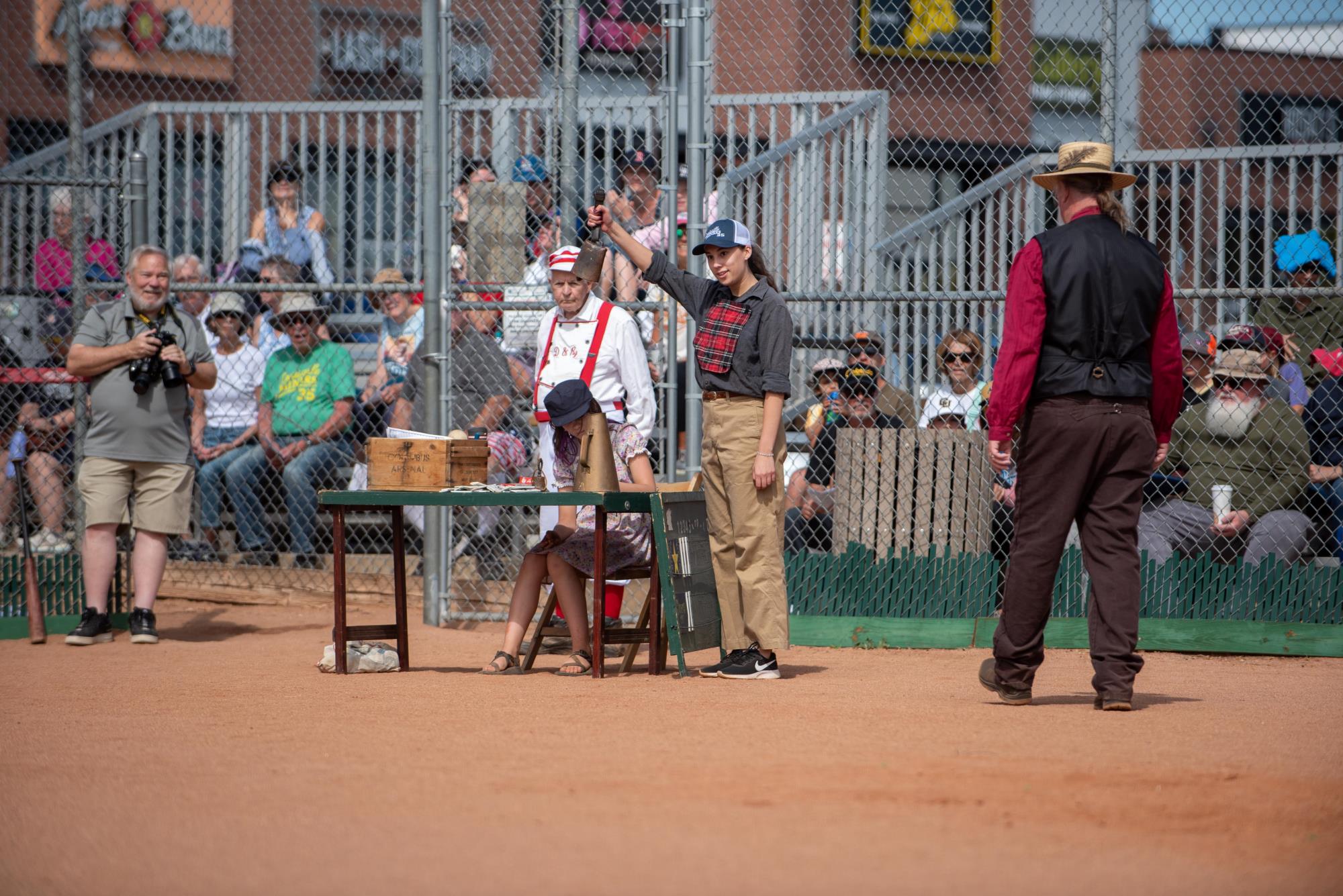 a woman in a vintage uniform rings a bell