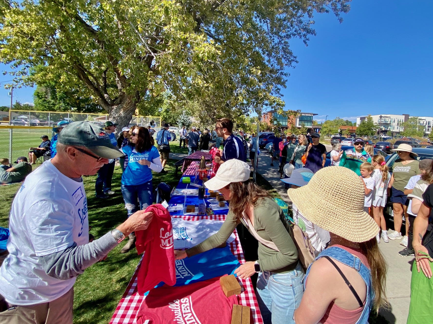 a volunteer holds a tshirt while people line up