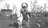 Chief Buckskin Charlie on Horseback in full regalia and headdress